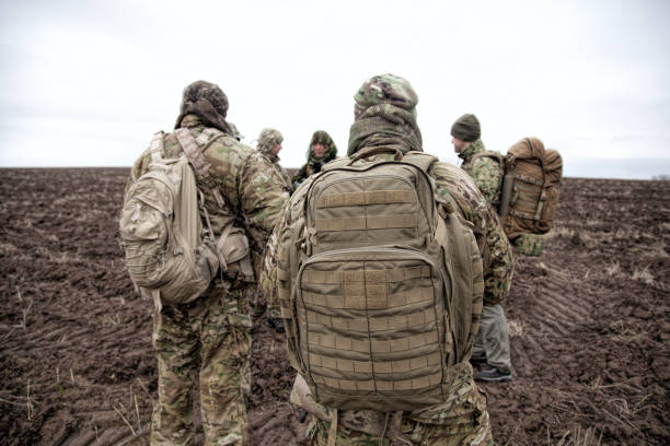 Soldiers with tactical backpacks in a field