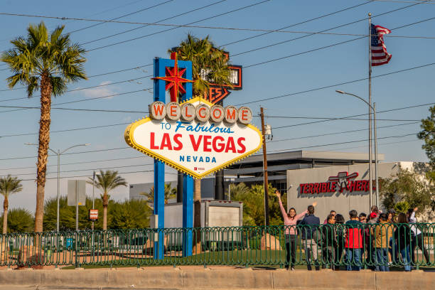 una mujer frente al famoso letrero de bienvenida a las vegas fabulosa. - welcome to fabulous las vegas sign photography landmarks travel locations fotografías e imágenes de stock