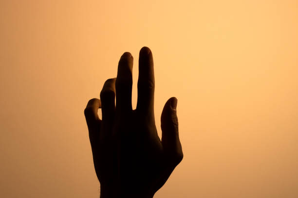 istock Hand finger silhouette light broke warm 1192575076