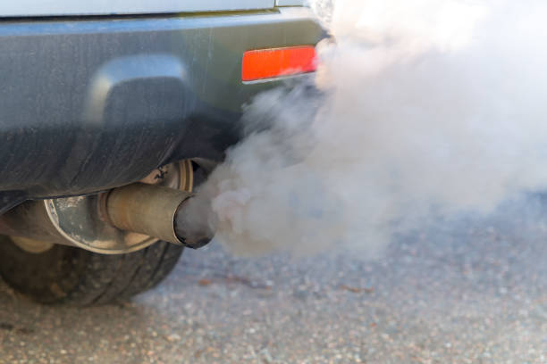 Car Exhaust Smoke Closeup Thick smoke pours from the exhaust pile on a car. Shallow depth of field, focus on the end of the tail pipe. Closeup view. exhaust pipe photos stock pictures, royalty-free photos & images