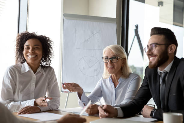 istock Smiling diverse colleagues laugh brainstorming at office briefing 1192579014
