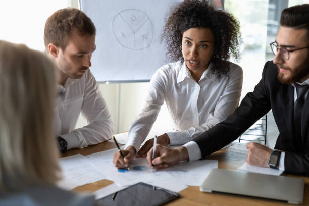 istock Multiethnic colleagues discussing financial paperwork at briefing 1192579025
