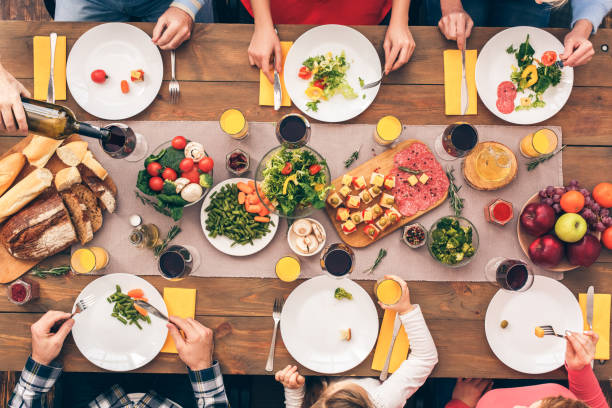 istock Family sitting at home, eating dinner together 1192579071
