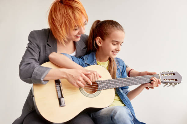 istock Diligent girl learning playing guitar with individual teacher 1192579162