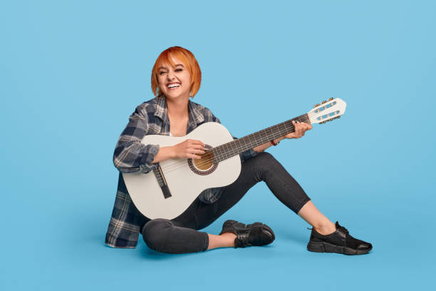 istock Smiling woman playing guitar 1192579172