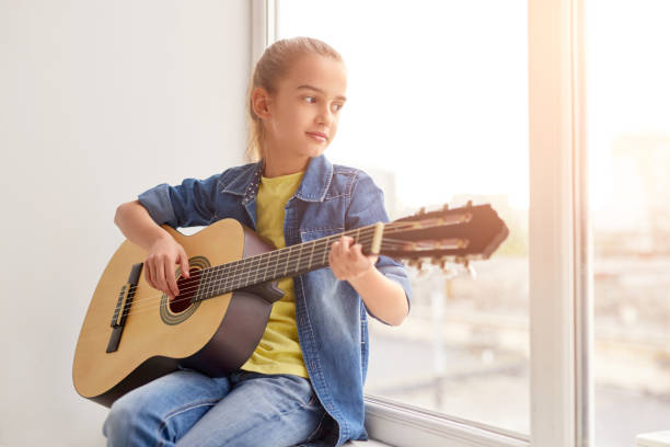 istock Girl playing guitar near window 1192579173