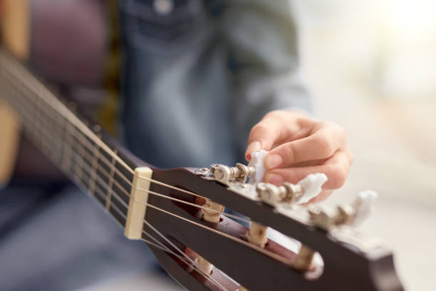 istock Anonymous musician tuning acoustic guitar 1192579178