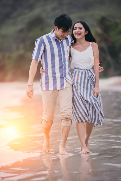 istock Happy romantic couples strolling and watching the beautiful sunset on the evening beach. Warm love on valentine's day. 1192595029