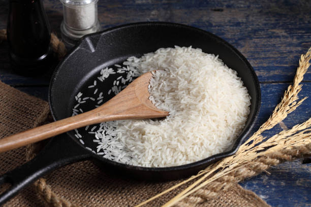 istock Close up white rice in measuring cup on table, Thai Jasmine rice in rustic kitchen background 1192599290