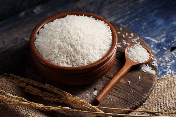 istock Close up white rice in measuring cup on table, Thai Jasmine rice in rustic kitchen background 1192601261
