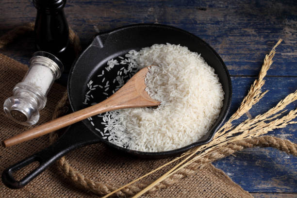 istock Close up white rice in measuring cup on table, Thai Jasmine rice in rustic kitchen background 1192601285