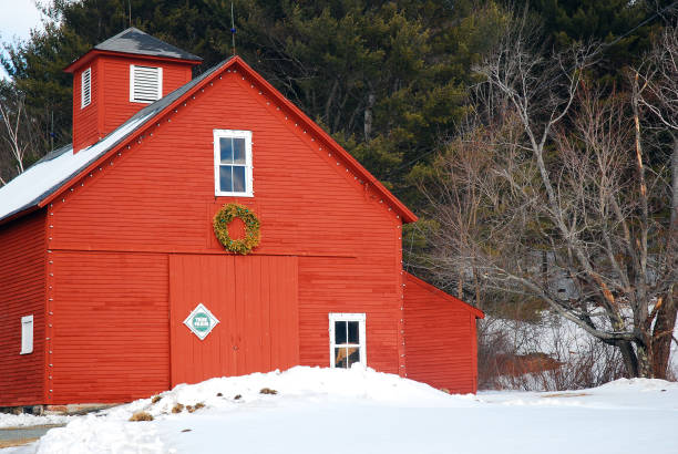 Christmas red barn A red barn, surrounded by snow, is decorated for Christmas with a wreath red barn house stock pictures, royalty-free photos & images