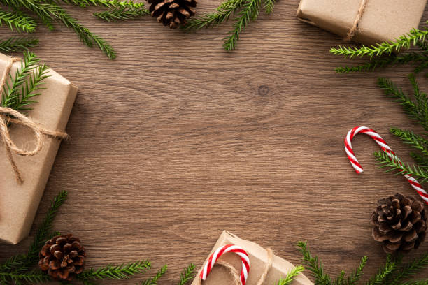 istock Wood table with Christmas decoration including gift boxes, candy cane, pine branches and pine cones. Merry Christmas and happy new year concept. Top view with copy space, flat lay. 1192603020