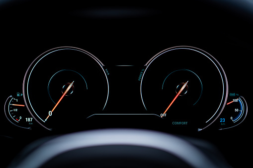 Modern digital dashboard behind the steering wheel in plug in hybrid vehicle, PHEV, close up.