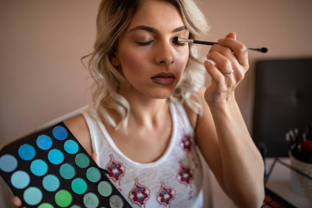 istock Beautiful young woman applying eyeshadow 1192603981