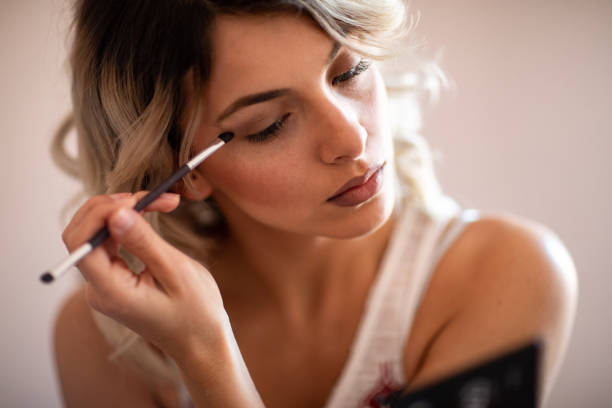 istock Beautiful young woman applying eyeshadow 1192605393