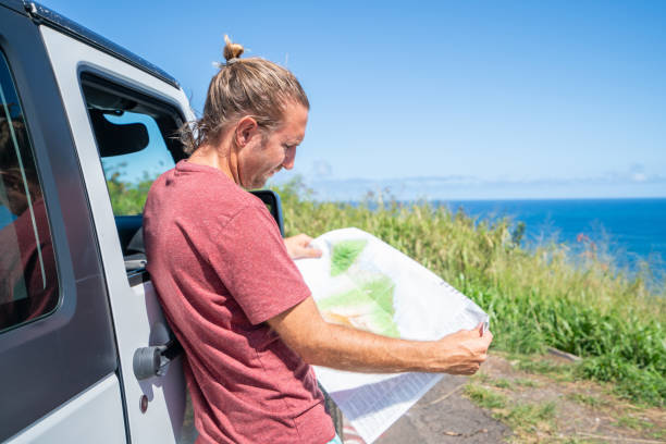 istock Young man on road trip looking at road map 1192607145