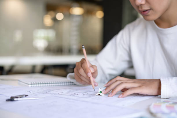 istock Cropped shot of creative Architect designing and sketching the building construction project at workplace. 1192607913