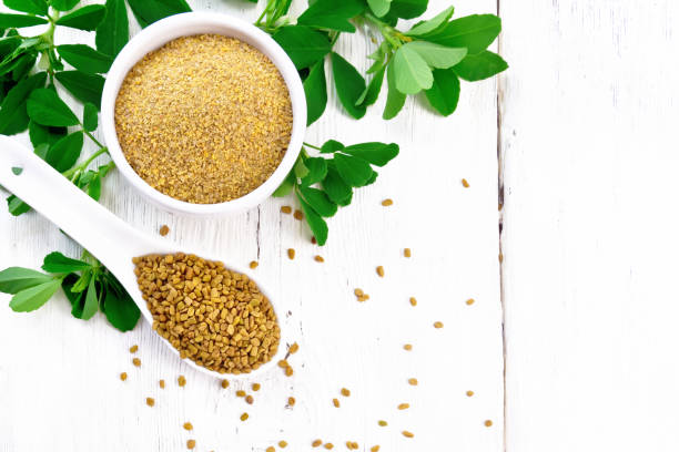 istock Fenugreek in spoon and bowl with leaves on board top 1192610687
