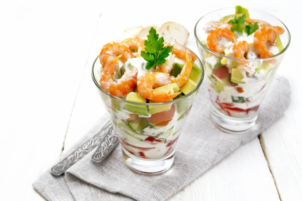 salad with shrimp and avocado in two glasses on light board - cocktail avocado imagens e fotografias de stock