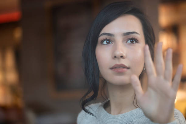 Young woman looking outside through the window