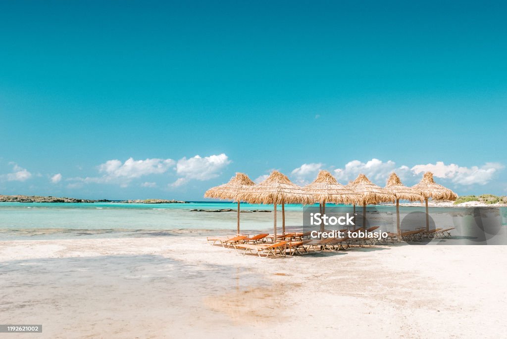 Elafonissi beach on the Crete island, Greece. Empty sunbeds on the Elafonissi beach on the Crete island, Greece. Seen a hot sunny day in the summer. Crete Stock Photo