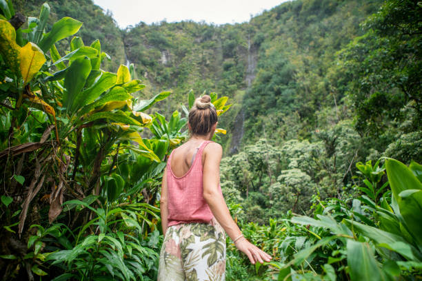 Young woman walking in tropical rainforest exploring nature