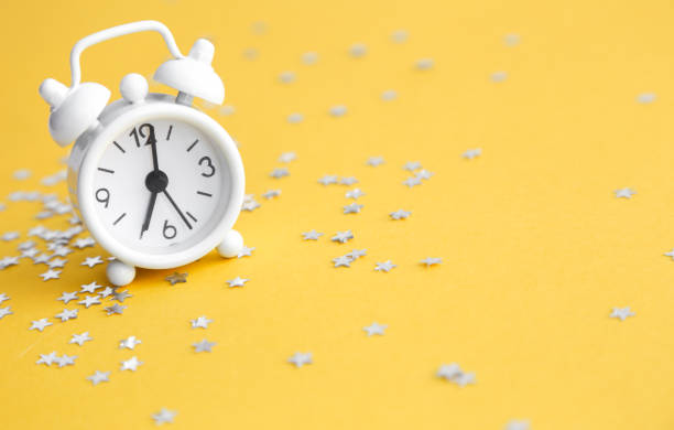 istock White table clock, alarm on yellow background, top view. Good morning. Minimalism, flatlay 1192621757