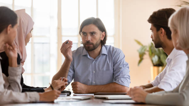 istock Serious male team leader explaining project details to concentrated colleagues. 1192624583