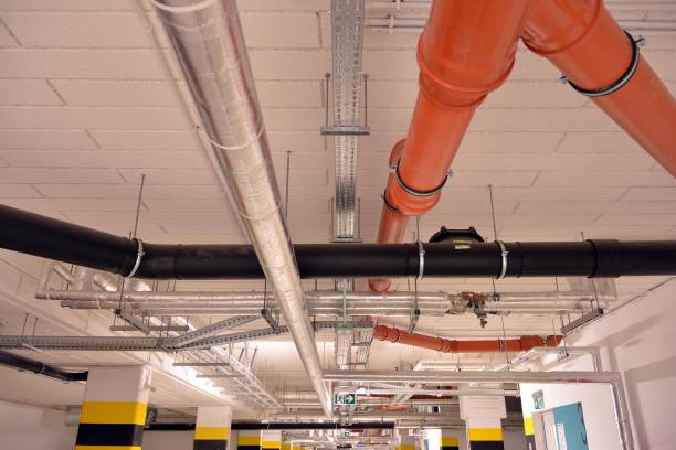 istock Water pipes and cable trays run under ceiling of a building 1192624900