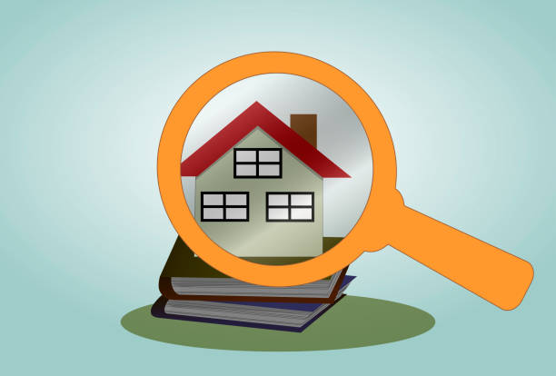 istock House and stack of bank books on under a magnifying glass. 1192625769