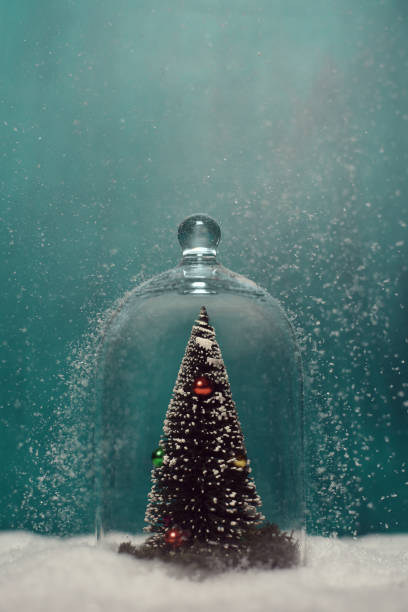 istock Toy christmas tree under a glass jar on a green background. 1192625853