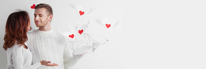 Couple releasing love concept, man and woman open cage with winged hearts, valentines day white and red colors