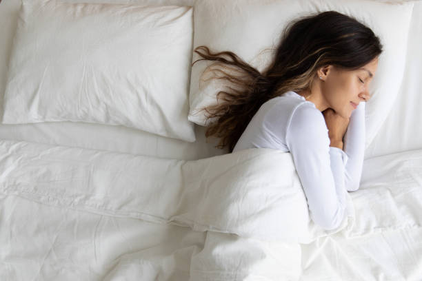 вид женщины, спящей на одной стороне кровати - sleeping women pillow bed стоковые фото и изображения