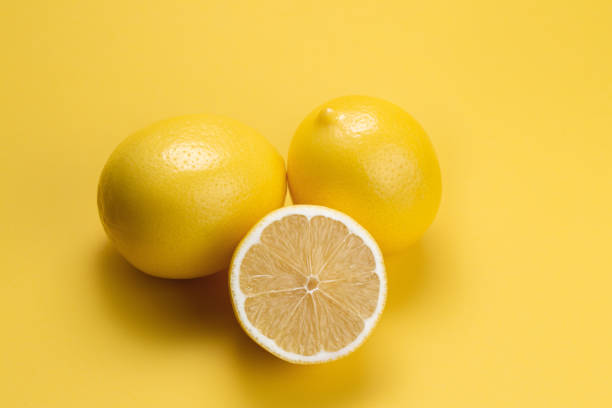 istock Lemon fruit slice and whole lemons on yellow background. 1192635040