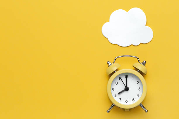istock Yellow round alarm clock and white cloud on the yellow background. 1192635088