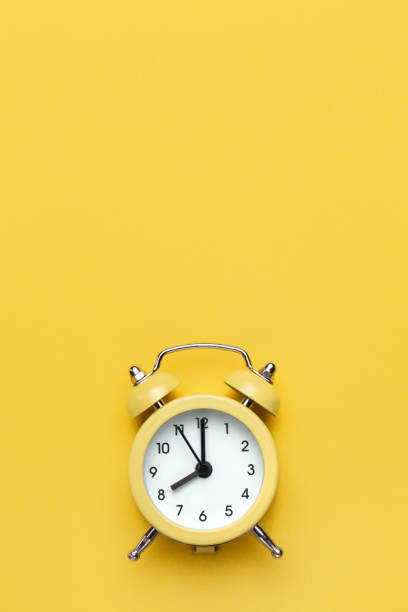 istock Yellow round alarm clock on the yellow background. 1192635089