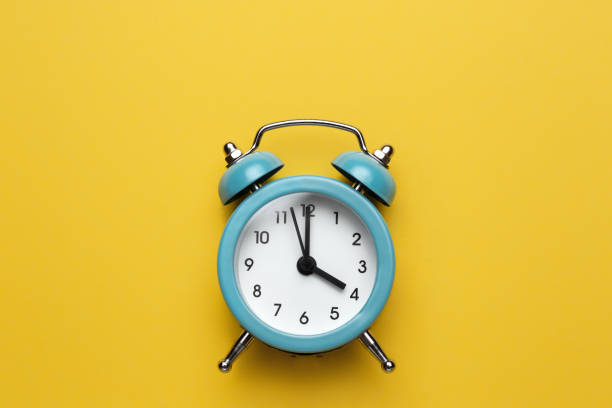 istock Blue round alarm clock on the cyan background. 1192635115