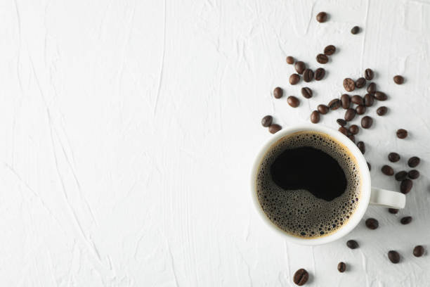 istock Cup of coffee and beans on white background, top view 1192637210