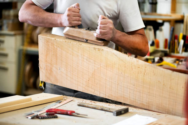 istock Carpenter working with a planer on a block of wood 1192638078
