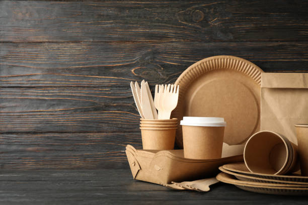 istock Eco - friendly tableware and paper bag on wooden table, copy space 1192638907