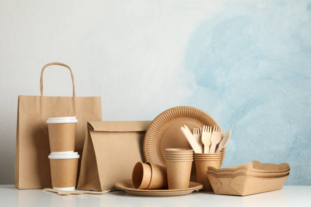 istock Eco - friendly tableware and paper bag on white table, space for text 1192639107