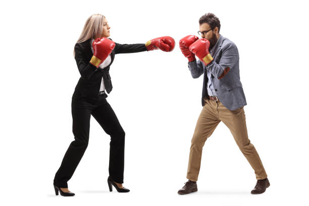 homme et femme dans les vêtements formels combattant avec des gants de boxe - women business strength boxing photos et images de collection