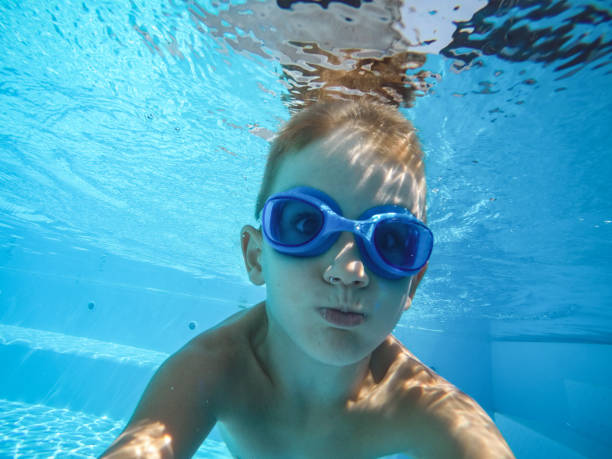 istock Happy kid enjoying while diving in pool 1192641269