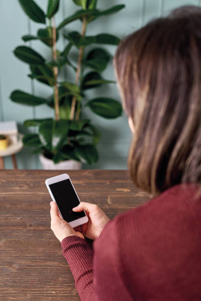 istock Woman holding and touching blank screen template smart phone. Smart phone screen is empty with clipping path. 1192642019
