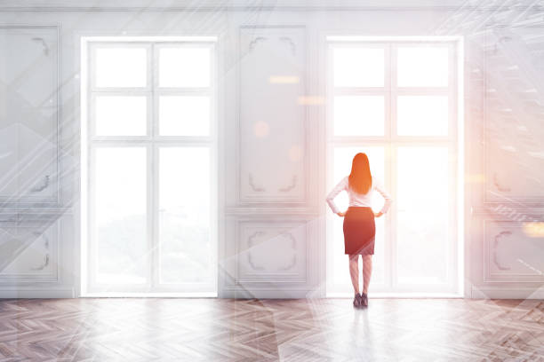 istock Woman in suit in empty room with windows 1192642096