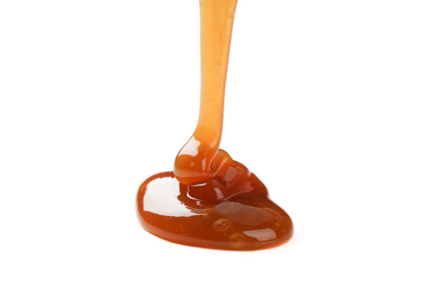 istock Pouring brown caramel isolated on white background 1192642215