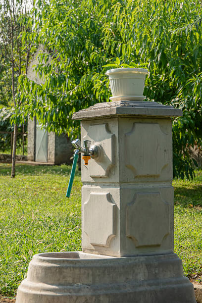 stone fountain in the backyard - well fountain water pipe pipe imagens e fotografias de stock