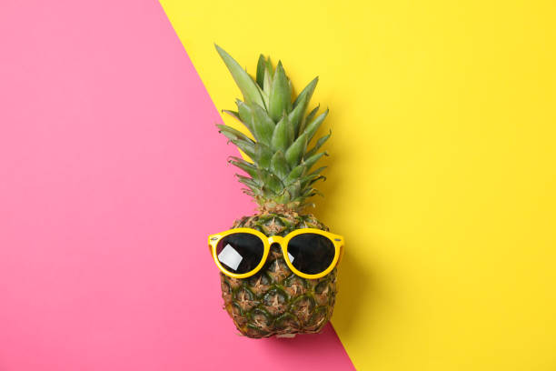 istock Pineapple with sunglasses on two tone background, space for text 1192643119