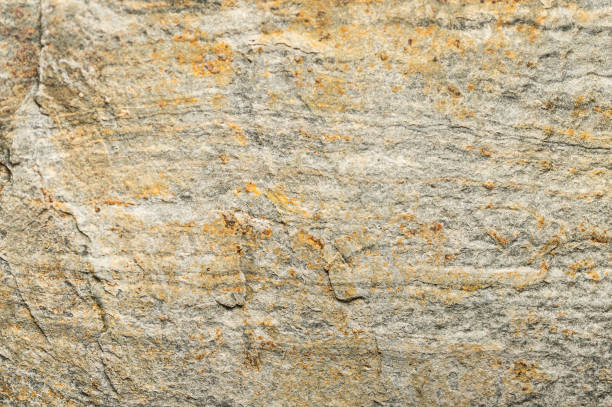 istock Texture of gray stone with a natural pattern and yellow splashes. Universal background. 1192643393
